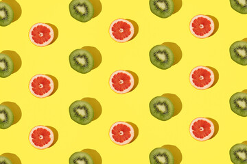 Arranged kiwi and grapefruit on a minimal yellow background.