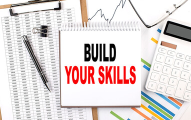 BUILD YOUR SKILLS text on notebook with chart, calculator and pen