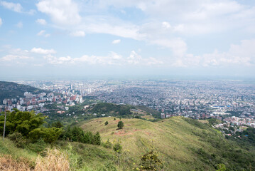 Fototapeta premium Stadtpanorama von Cali mit Draufsicht von Cristo Rey Statue in Kolumbien