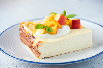 Breakfast ricotta or cottage cheese casserole served with greek yogurt and peach. Healthy sweet cheese cake