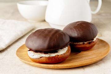 airy biscuit cake with a layer of butter cream, in chocolate icing