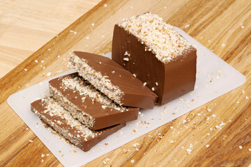 Rectangular chocolate pudding with nut crumbs cut into slices. 