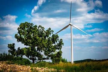 Wind turbine in summer landscape in front of cloudy sky in Hungary