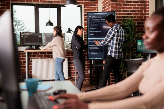 Tech enginners using binary code to script security system, programming firewall encryption. Diverse team working with program data server to develop network on coding software. Programmer concept - Powered by Adobe