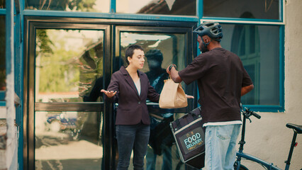 Aggressive client yelling at food delivery service worker, shouting about problem with takeaway meal order. African american courier dealing with angry customer, giving wrong food. Handheld shot.