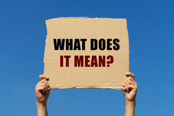 What does it mean text on box paper held by 2 hands with isolated blue sky background. This message...