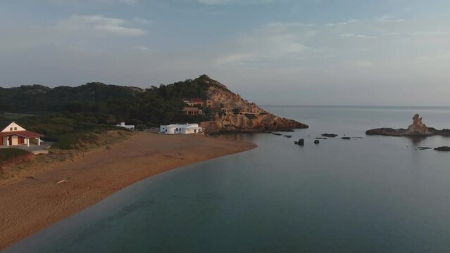 Luxury house in hidden Menorca bay. Sunset with drone flying over properties.