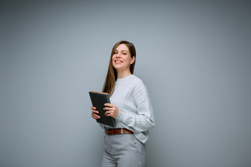 Fototapeta premium Smiling female teacher or young business woman holding book isolated portrait.