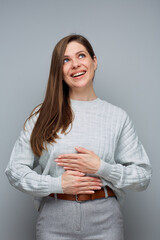 Happy cheerful woman looking up holding hands on stomach. isolated portrait.