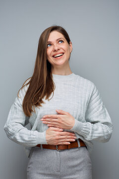 Happy cheerful woman looking up holding hands on stomach. isolated portrait.