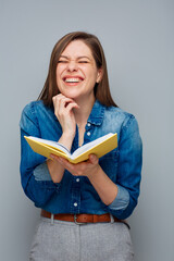 Portrait of excited woman teacher or student with yellow book and closed eyes.