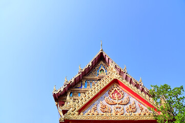 Fototapeta premium BANGKOK, THAILAND - March 29, 2023 : Part of the Roof of a temple in Thailand. Traditional Thai style pattern on the roof of a temple with Blue Sky Background.