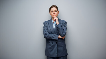 Obraz na płótnie Canvas Portrait of thinking serious business woman on gray background.