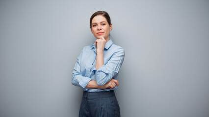 Portrait of serious business woman on gray wall background.