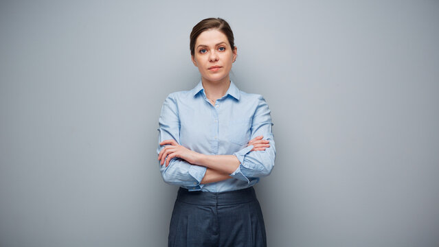 Portrait of serious business woman on gray wall background.