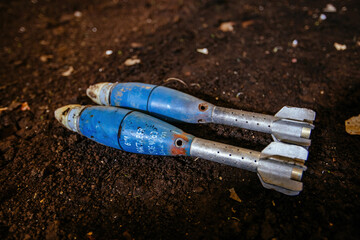 Unexploded mortar mines on ground. War actions aftermath