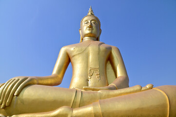 BANGKOK, THAILAND : March 29, 2023 - The Big Golden Buddha Statue with blue sky and white cloud in Buddhist temples in Bangkok, Thailand. Concept for those who have faith to come to pay respect.