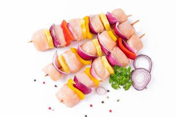 Top view.Skewers with pieces of raw meat, red, yellow and green pepper.Raw pieces of chicken skewers with pepper onion and pineapple on a white background.Uncooked mixed meat skewer with peppers.