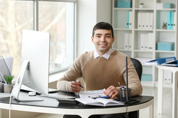 Fototapeta na wymiar Young accountant working with document at table in office