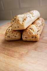 Panini rolls on a wooden board in a kitchen. Premium bread product with high quality and great taste. Healthy food.