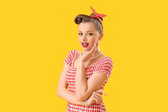 Young pin-up woman on yellow background