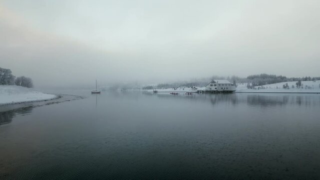 Snowy nordic landscape on cloudy day, Kvaloya or Sallir island, Tromso in Norway. Aerial sideways