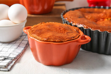 Delicious meat pies in baking forms on white table