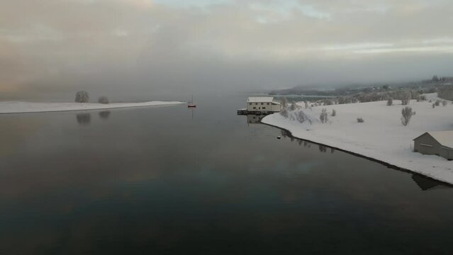 Fjord Norwegian in snowy landscape on cloudy winter day. Aerial drone panoramic view and space for copy