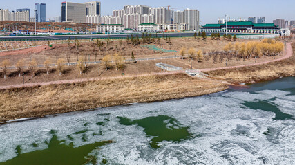 Fototapeta na wymiar Landscape along the Yitong River in Changchun, China with melting ice and snow