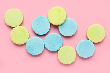 Green and blue soluble tablets on pink background