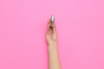 Woman with anal plug on pink background
