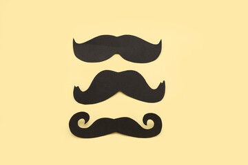 Set of black paper mustaches on color background