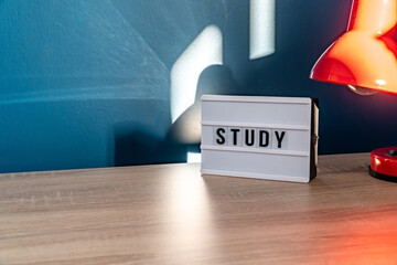 Study background concept. Study room concept. Wooden table or desk with lamp in a home with natural daylight. Comfortable workplace. Selective focus included.