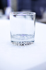 a transparent glass stands on a white tablecloth on a buffet table celebration breaking a ban on drinking alcohol