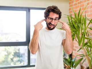 young adult crazy man with expressive pose at a modern house interior