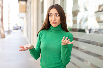 young pretty woman feeling puzzled and confused, unsure about the correct answer or decision,...