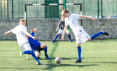 Fototapeta premium Youth football player kicking ball in direction of goal