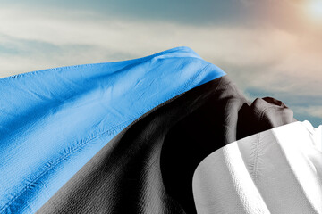 Estonia national flag cloth fabric waving on beautiful grey sky.