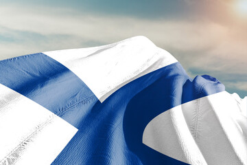 Finland national flag cloth fabric waving on beautiful grey sky.