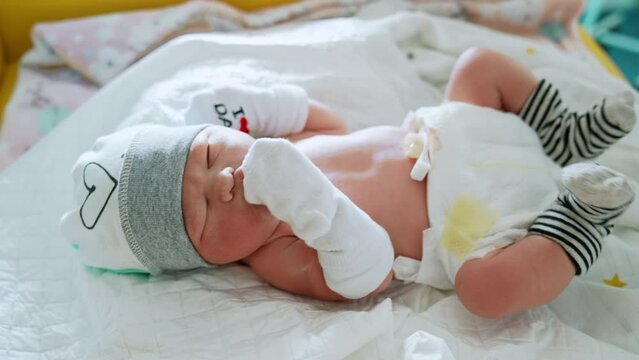 Adorable newborn child in the maternity hospital. Pediatrician listens to the heartbeat of an infant. Nurses take care of a baby.