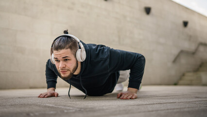 One man young adult caucasian male training outdoor doing push ups