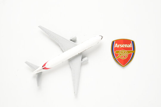  A picture of Arsenal Football Club logo with Fly Emirates Miniature plane on white background. Fly Emirates as main flight to London and home of EPL Champion."