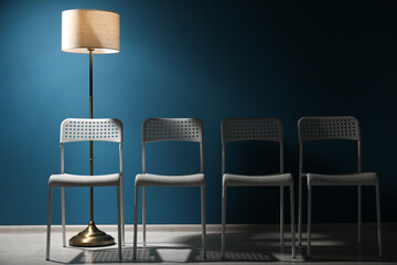 White chairs and lamp near blue wall. Recruiter searching employee