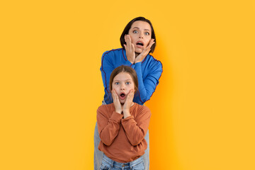 Portrait Of Shocked Mother And Little Daughter Looking At Camera