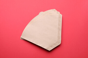 Paper coffee filters on red background, flat lay