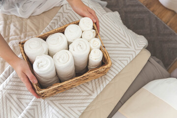 Fototapeta na wymiar Woman hands neatly folded linens and towels. Japanese storage method.