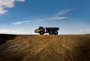 Heavy hauler transporter in a deserted area against a striking blue sky