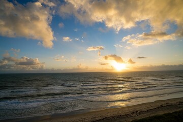 a beautiful sun set over the ocean on a beach side
