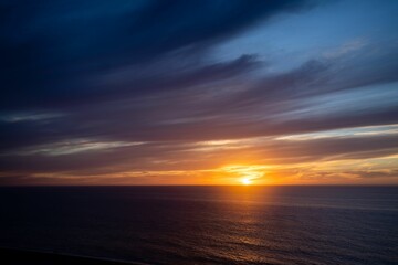 the sun rises on the horizon of the ocean during the day