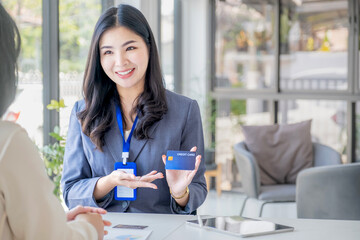 Obraz premium Young Asian officer woman hand holding a credit card, for spending pay online shopping according to discount products